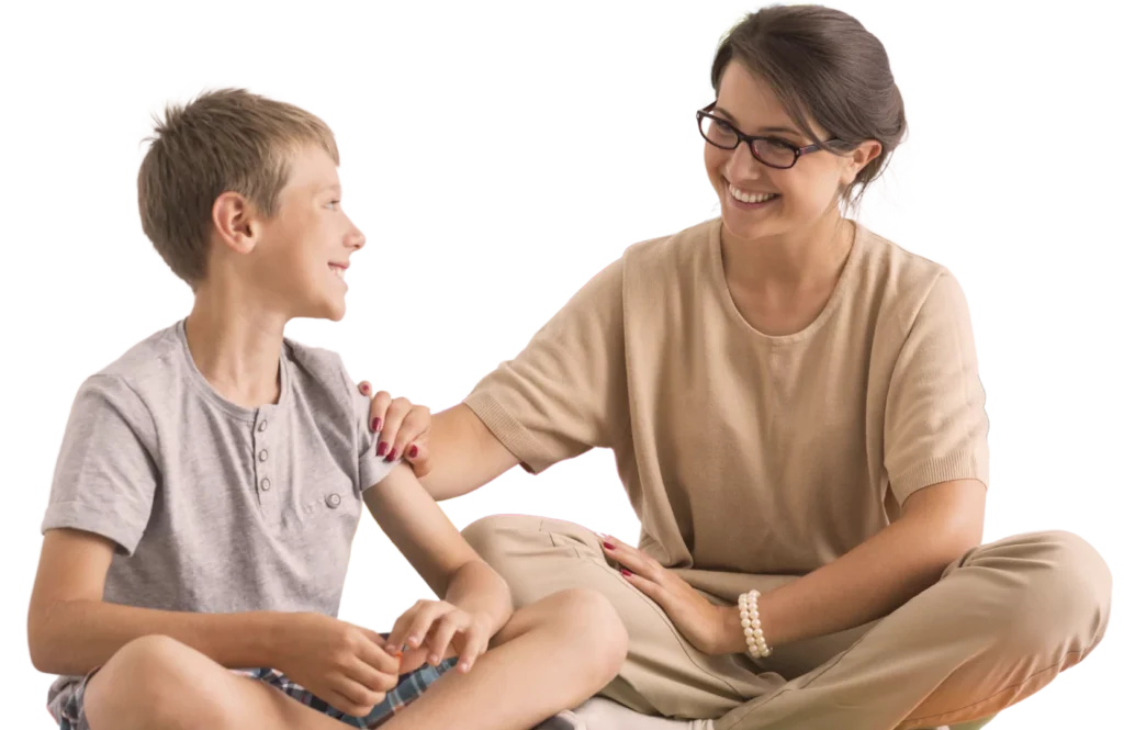 A female play therapist is talking though mental health with a young boy