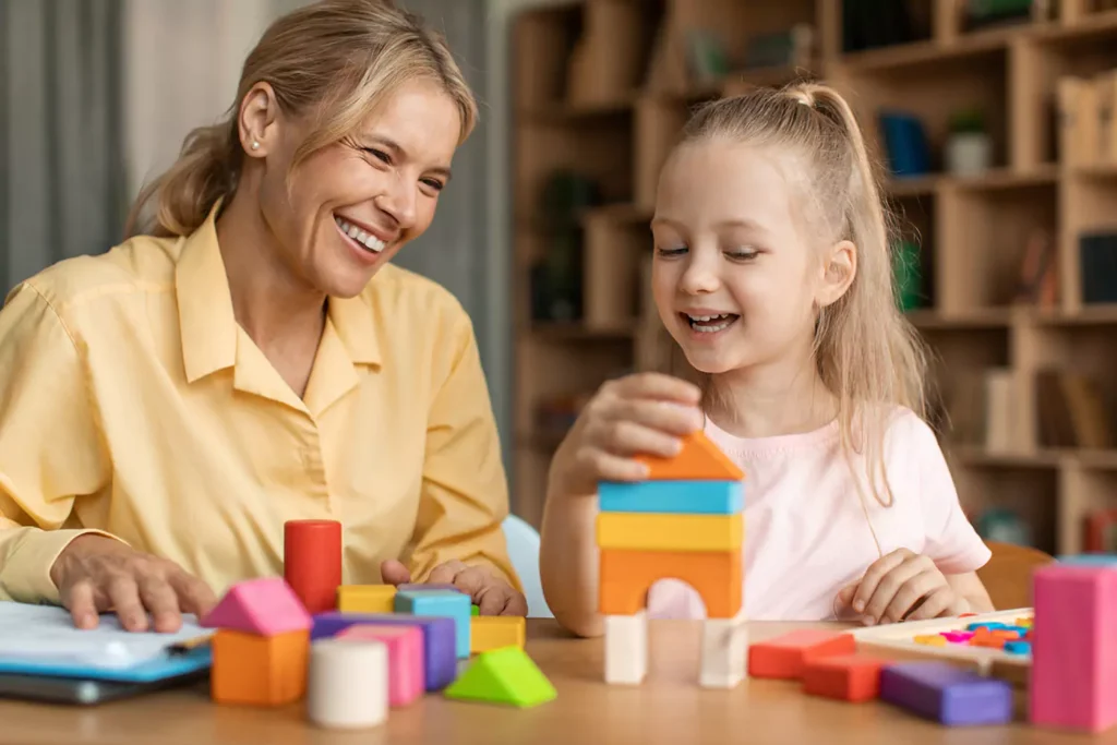 A young girl is engaged in play therapy with her therapist
